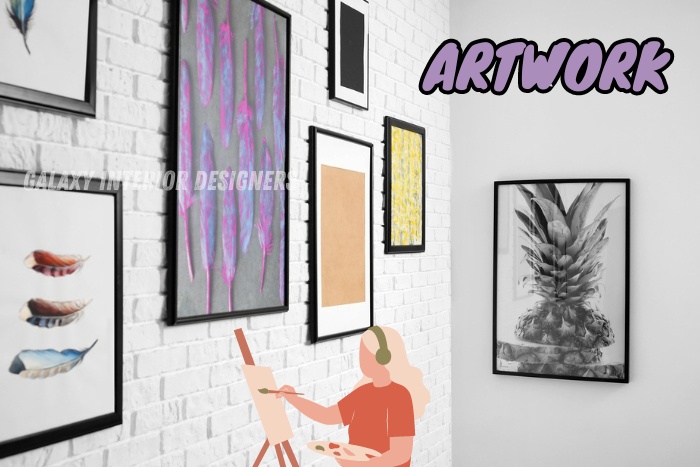 Artist creating new artwork in a gallery setup by Galaxy Interior Designers in Chennai, with diverse framed art pieces including abstract and realistic styles on a white brick wall
