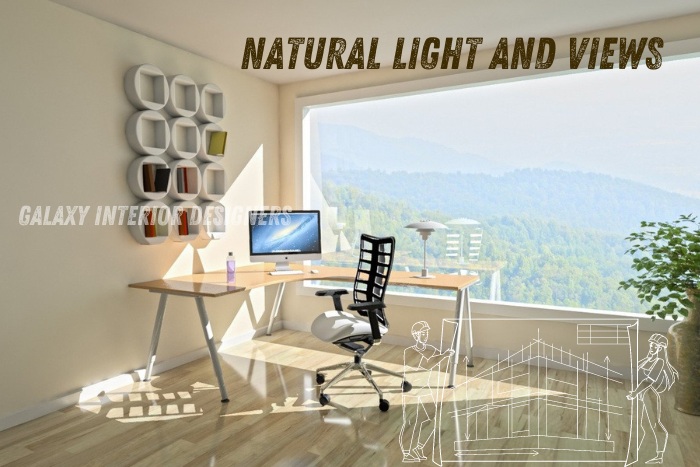 Office design with natural light and views by Galaxy Interior Designers in Chennai, featuring a spacious desk setup, ergonomic chair, and large windows overlooking scenic greenery